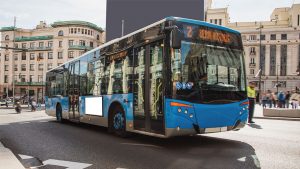 Plano largo de un autobús urbano madrileño de color azul y con un letrero que indica: "Línea 2, Reina Victoria".